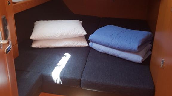 In der Doppelkabine der Segelyacht Vivi ist ein Bett mit Kissen und Decken zu sehen.