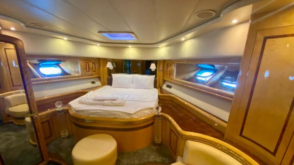 Luxury cabin of motor yacht Ser 1 featuring a large bed and wooden accents.