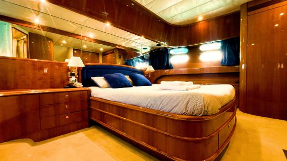 The master cabin of motor yacht Riva 21 features a large bed and luxurious decor.