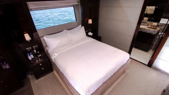 The guest bedroom of the Legende motor yacht, featuring sea views, adds comfort to your Dubai yacht rental experience.