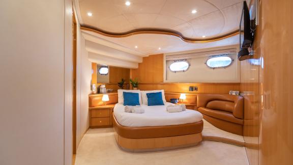 Das Schlafzimmer der Motoryacht Lady L zeigt ein großes Bett und einen komfortablen Sitzbereich.