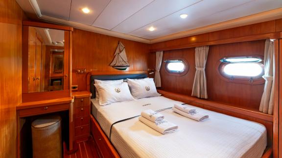 The cabin of Mein Schatz features sea-view windows and a cozy bed, perfect for a weekly gulet charter in Bodrum.