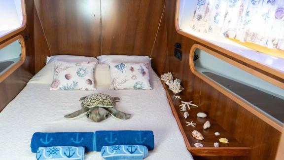 Cabin with sea-themed pillows, decorations, and cozy bed on Barbaros 3 yacht.