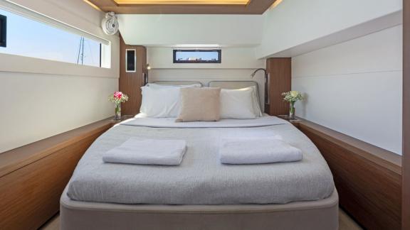 The My Star catamaran offers a spacious cabin with a large bed, side windows, and minimalist comfort for restful nights.