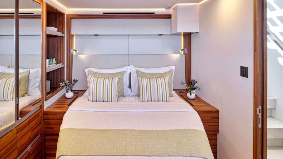 Bed with pillows, shelves and natural light create a calm onboard atmosphere.