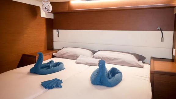 Akana’s cabin features a cozy bed, folded towels and warm wooden furnishings.