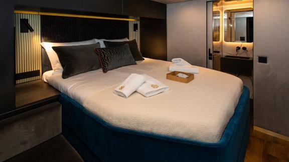 A stylish cabin on Sunreef 60 Mr. Si offers cozy bedding, elegant lighting and an en-suite bathroom for comfort.