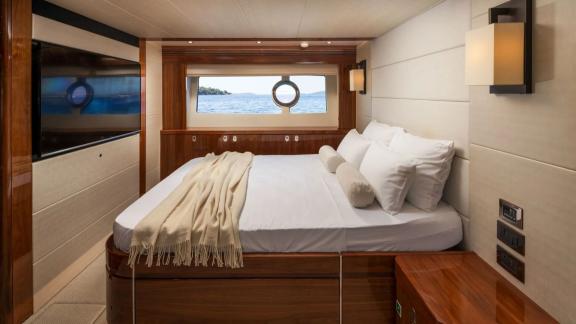 The Sunseeker 75 features a spacious bedroom with a large bed, sea views and a flat-screen TV at anchor.