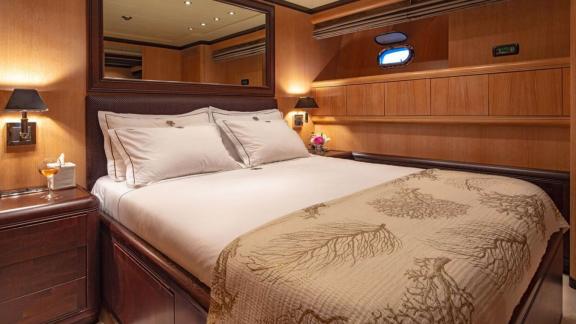 This Cosmos yacht cabin offers a serene retreat with warm lighting and wooden details.