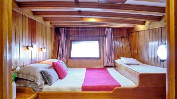 The wooden cabin of White Pearl gulet in Athens features a double bed and a single berth.