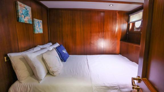 Gazella’s guest cabin features a double bed, a small window, and nautical-themed decor.