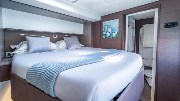 Comfortable cabin with a large bed and en-suite bathroom on the Bali Catamaran Signature Concept.