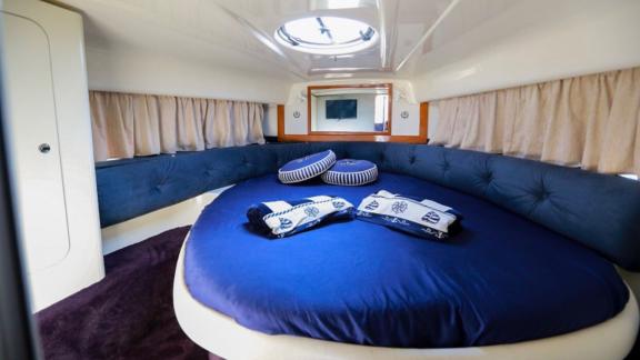 The cabin of Blondie yacht features a round bed and elegant navy-themed design accents