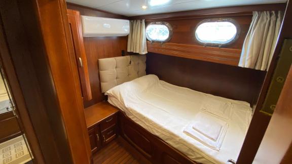 Одноместная каюта с двумя иллюминаторами и элегантным декором на гулете Be Happy в Бодруме.