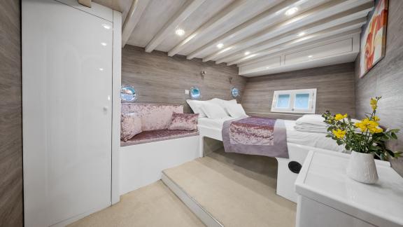 Geräumige Kabine mit großem Doppelbett, Sitzecke und modernem Design.