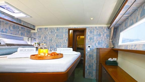 The master cabin of Ace of Hearts in Athens features a large bed, side window and entrance door.