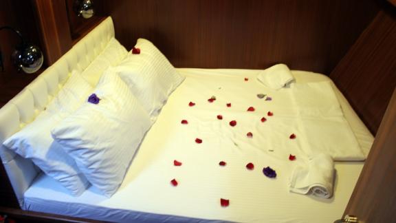 The carefully decorated bed with petals in the cozy cabin of the Gulet Life is Life.