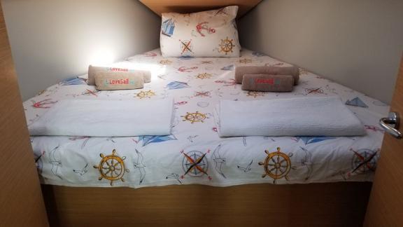 The cabin of the sailing yacht Ares offers a cozy sleeping area with nautical-themed bedding.