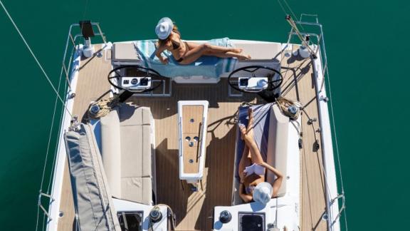 Two guests enjoying the sun on the deck of Joy 5 sailboat.