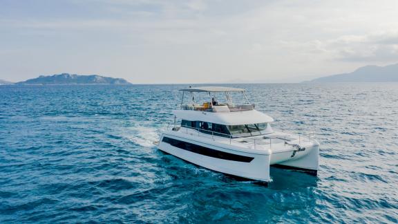 Sleek catamaran cruising open waters near the Greek islands. Perfect for exclusive yacht charters.