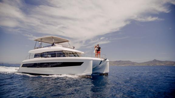 A couple enjoys the view aboard the Endless Beauty catamaran against a scenic island backdrop.