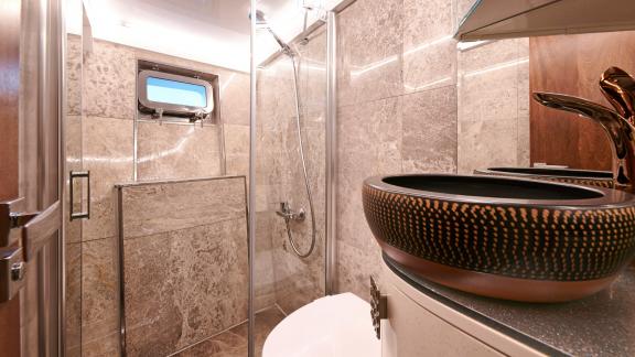 Modern guest bathroom of the motor yacht Wide Liberty with a luxurious shower and stylish sink.