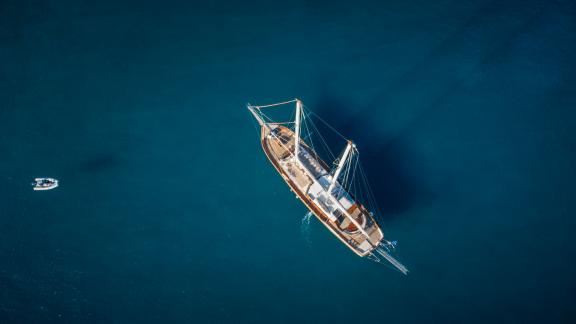 Aerial view of the gulet Entre Cielos, calmly anchored in the deep blue waters off the coast of Athens.