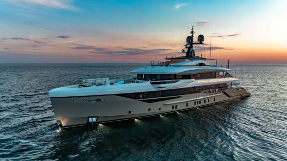 Eternal Spark motor yacht cruises on calm waters at sunset during an exclusive luxury yacht charter journey.