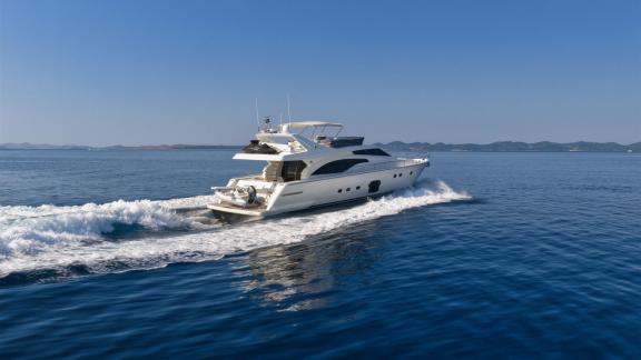 Ferretti 681 Dominique is seen cruising across open waters with its sleek profile and trailing wake.