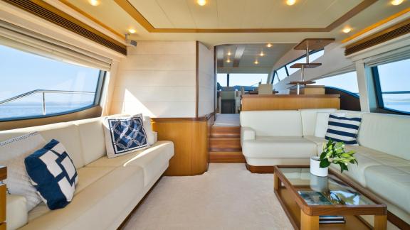 Ferretti 681 Dominique features a bright main saloon with large windows and comfortable seating areas.