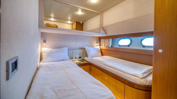Ferretti 681 Dominique features a guest cabin with twin beds, wood furnishings and side windows.