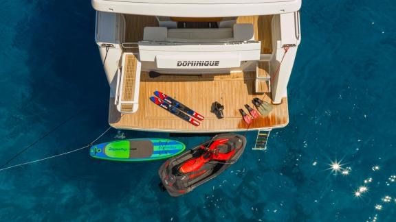 Ferretti 681 Dominique features a stern platform with a jet ski, paddle board and swim ladder.