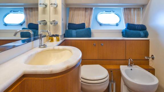 Ferretti 681 Dominique features a private bathroom with a sink, toilet, bidet and built in storage cabinets.