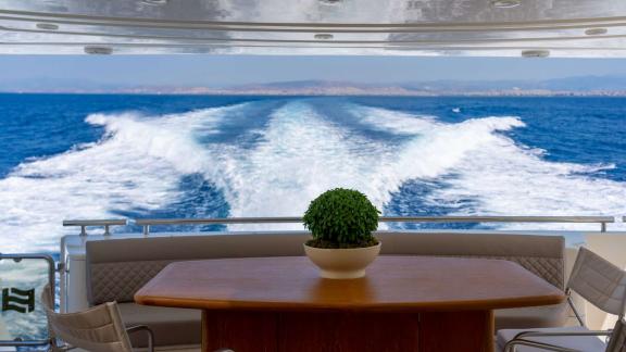Among Athens yacht rental options Sofia D aft deck shows sea view and wake trail while cruising.