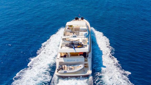 Among Athens yacht rental options Sofia D is cruising at sea with rear view and spacious deck visible.