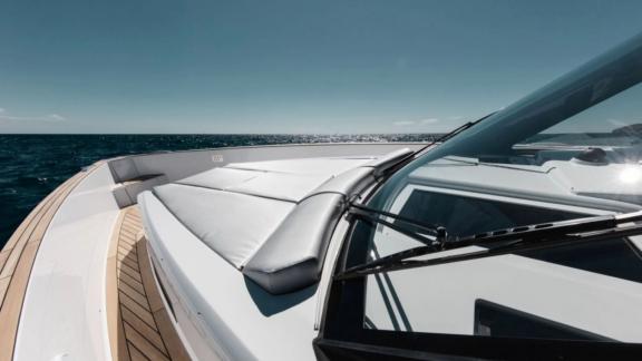 The foredeck of the Bombon motor yacht features wide grey sunbathing cushions.