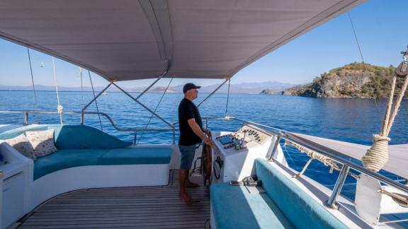 The captain steers Gulet Avuncan from the covered helm, overlooking the Aegean Sea.