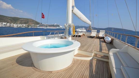 Das Achterdeck der Gulet Gül Sultan zeigt einen luxuriösen Whirlpool in der Mitte des eleganten Holzdecks.