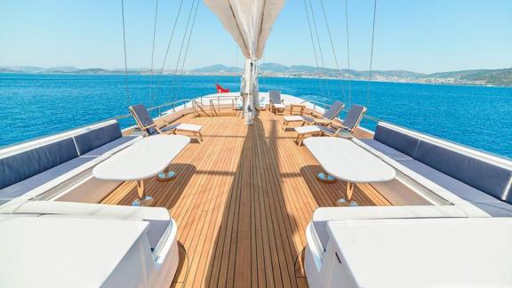 The spacious deck of the Gulet Bella Mare in Bodrum, furnished with comfortable seating and tables.