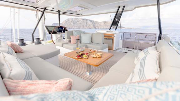 Comfortable seating area with snacks on the table, sea and coast in the background