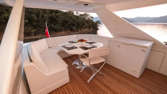 Das Oberdeck der Motoryacht Vega in Göcek bietet einen Essbereich mit Aussicht.