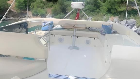 Flybridge area of motor yacht Rüzgar Demir with comfortable seating.