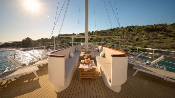 Komfortabler Entspannungsbereich auf der Bellezza Yacht mit gemütlichen Sofas und einem atemberaubenden Meerblick.