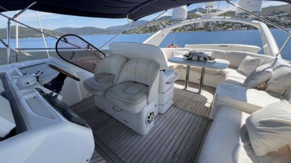 The flybridge area of the yacht Cielo features comfortable seating and a dining table with a stunning view.