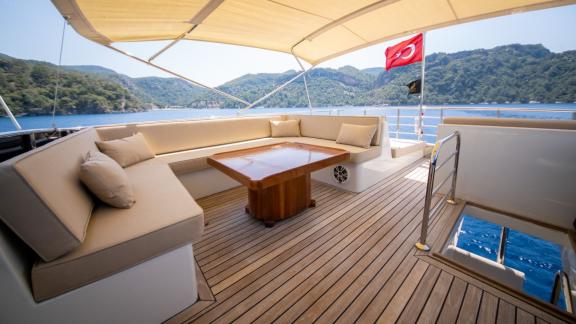 The upper deck of motor yacht Imperial features a comfortable seating area with an impressive view.