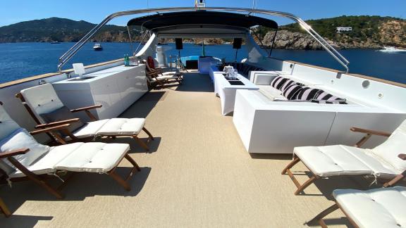 The spacious upper deck of Paula 3 yacht is equipped with comfortable loungers and a seating area.