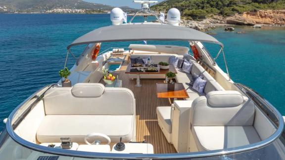 Comfortable seating area with cushions and a table on Divine's flybridge.