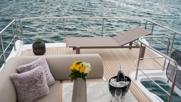 Sonnenliege, weiche Kissen und Champagner laden zum Entspannen direkt am Meer ein.