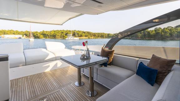 Beschatteter Bereich mit Tisch und Polstersofas für entspannte Stunden an Deck.