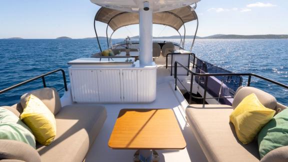 Cushioned flybridge seating and table aboard Olivia motor yacht near Šibenik.